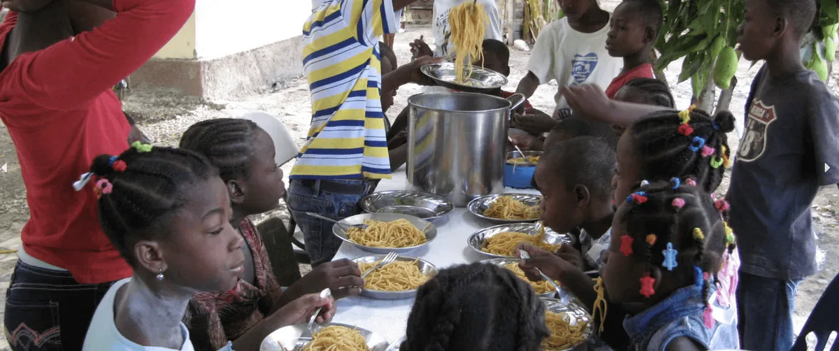 Children eating lunch together at a long table