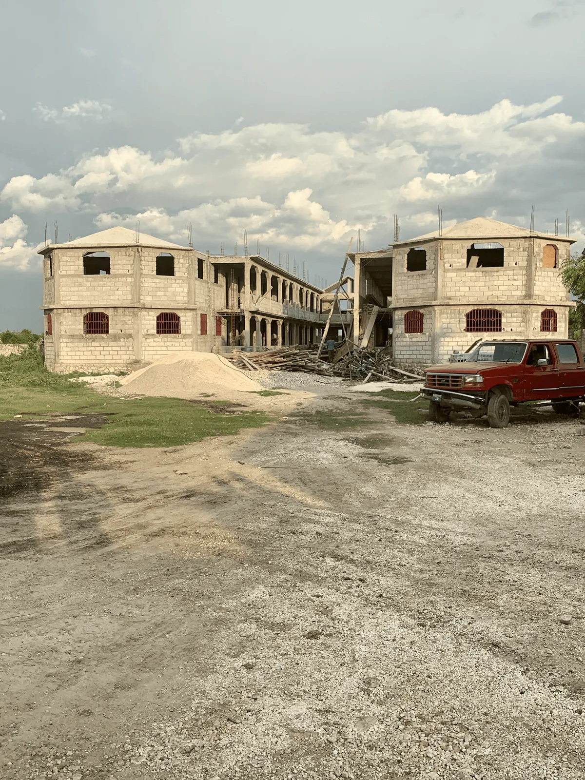 Two concrete buildings under construction beneath a cloudy sky