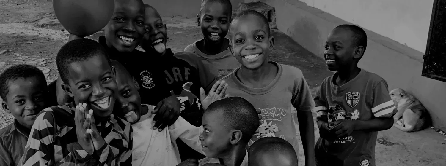 A group of boys laughing and waving at the camera