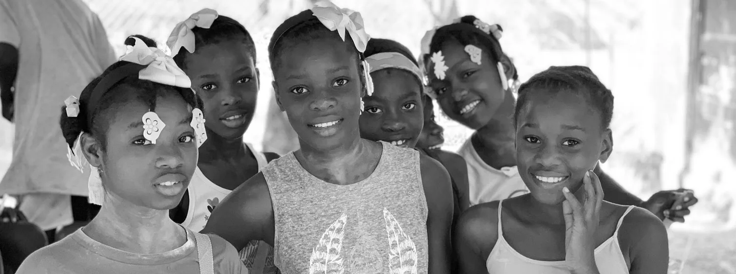 A group of girls in hair bows smiling at the camera